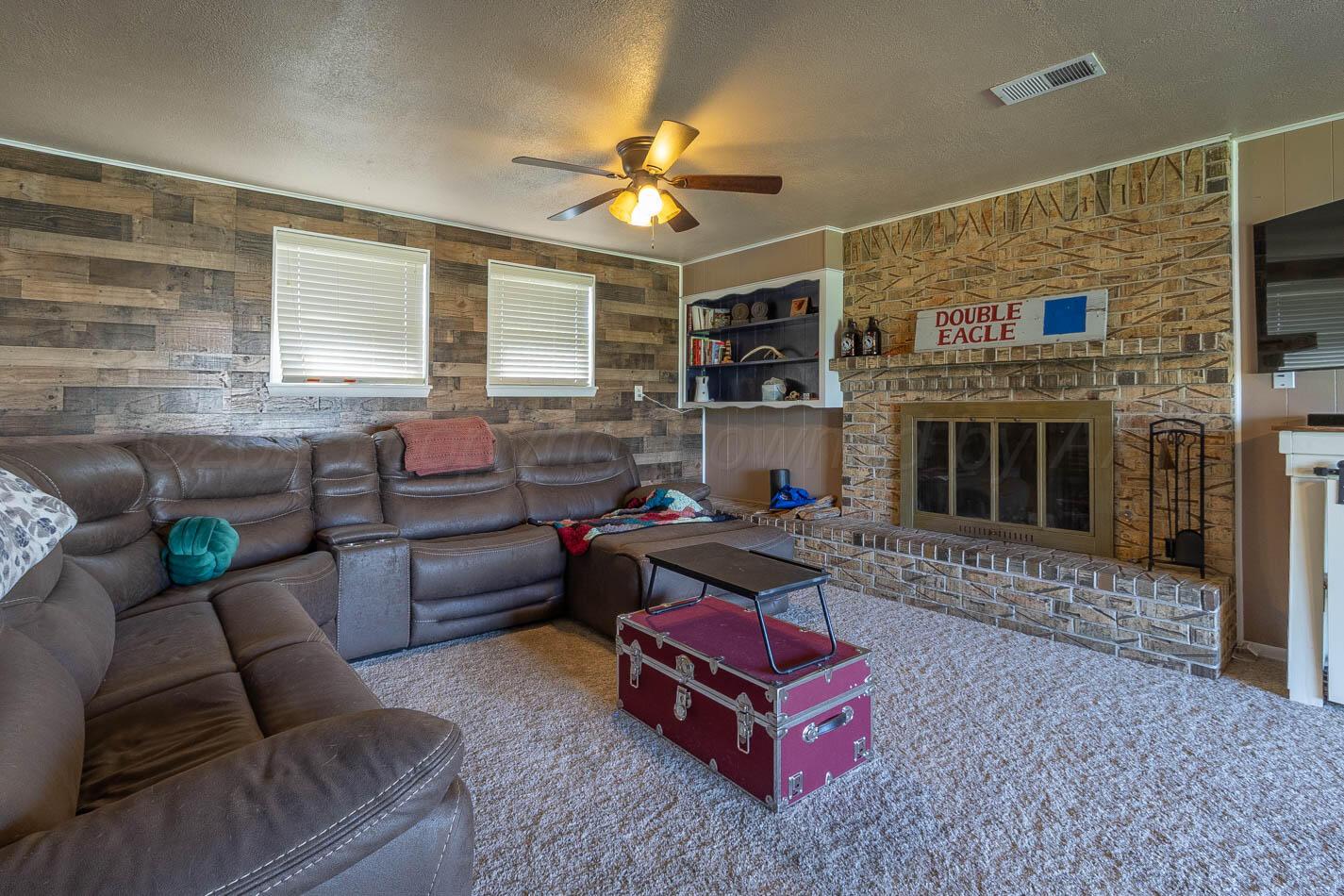 121 Houston Street Borger, TX 79007 - Photo 15 of 21 a living room with furniture a fireplace and a flat screen tv