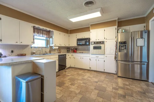 a kitchen with a refrigerator sink and cabinets