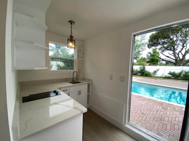 a view of a kitchen that has a sink and a wooden floor