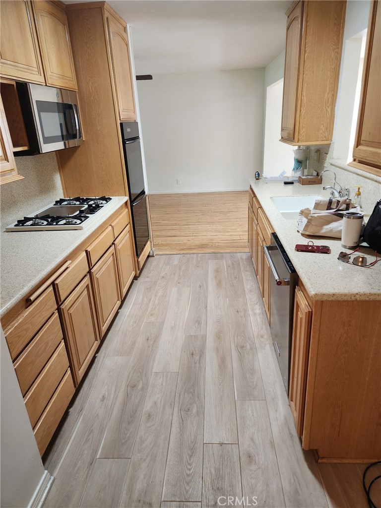 1011 East Chestnut Avenue Orange, CA 92867 - Photo 5 of 6 a kitchen with wooden floors and a stove