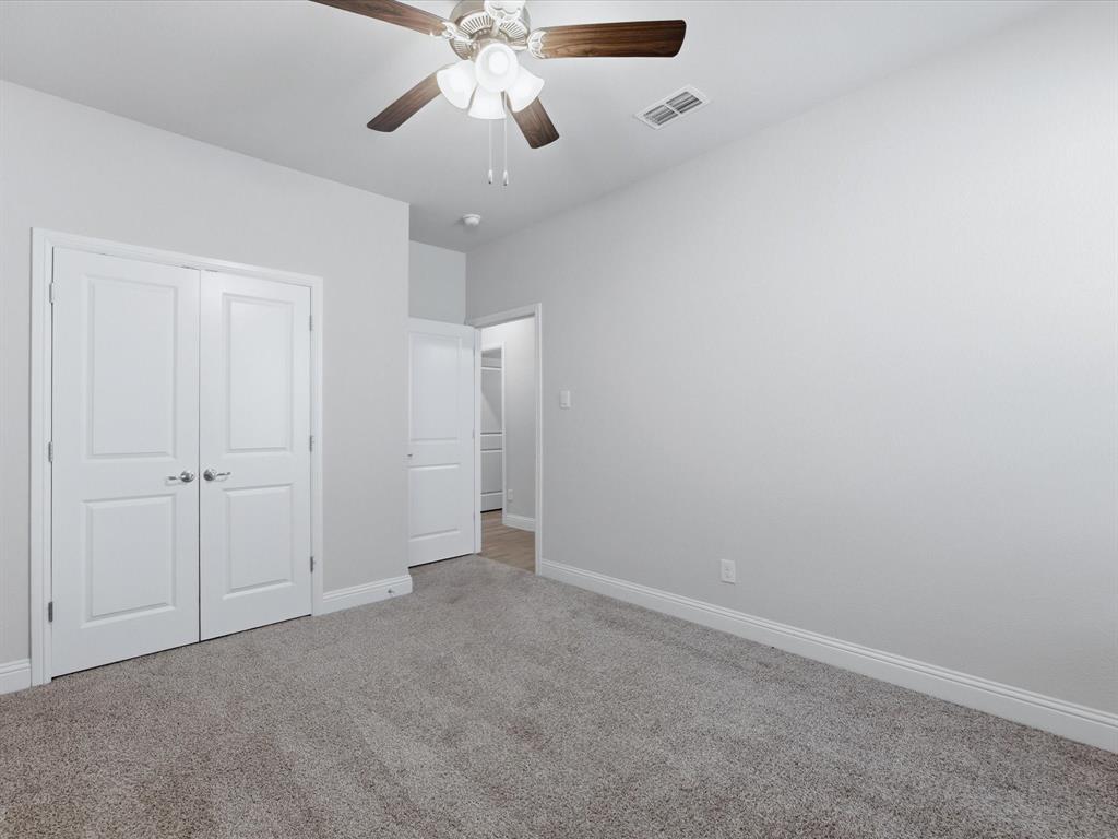 1121 Knightsbridge Road Argyle, TX 76226 - Photo 24 of 39 Room featuring a ceiling fan with light fixture, neutral wall paint, and gray carpet flooring