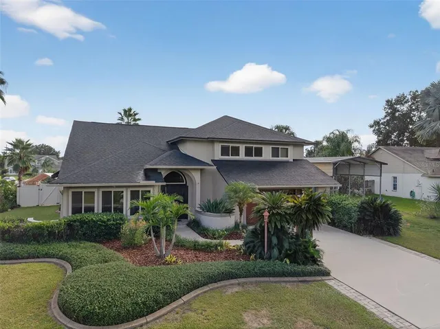 a front view of a house with a yard and potted plants