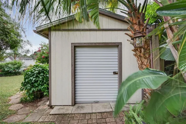 a front view of a house with a garden and trees