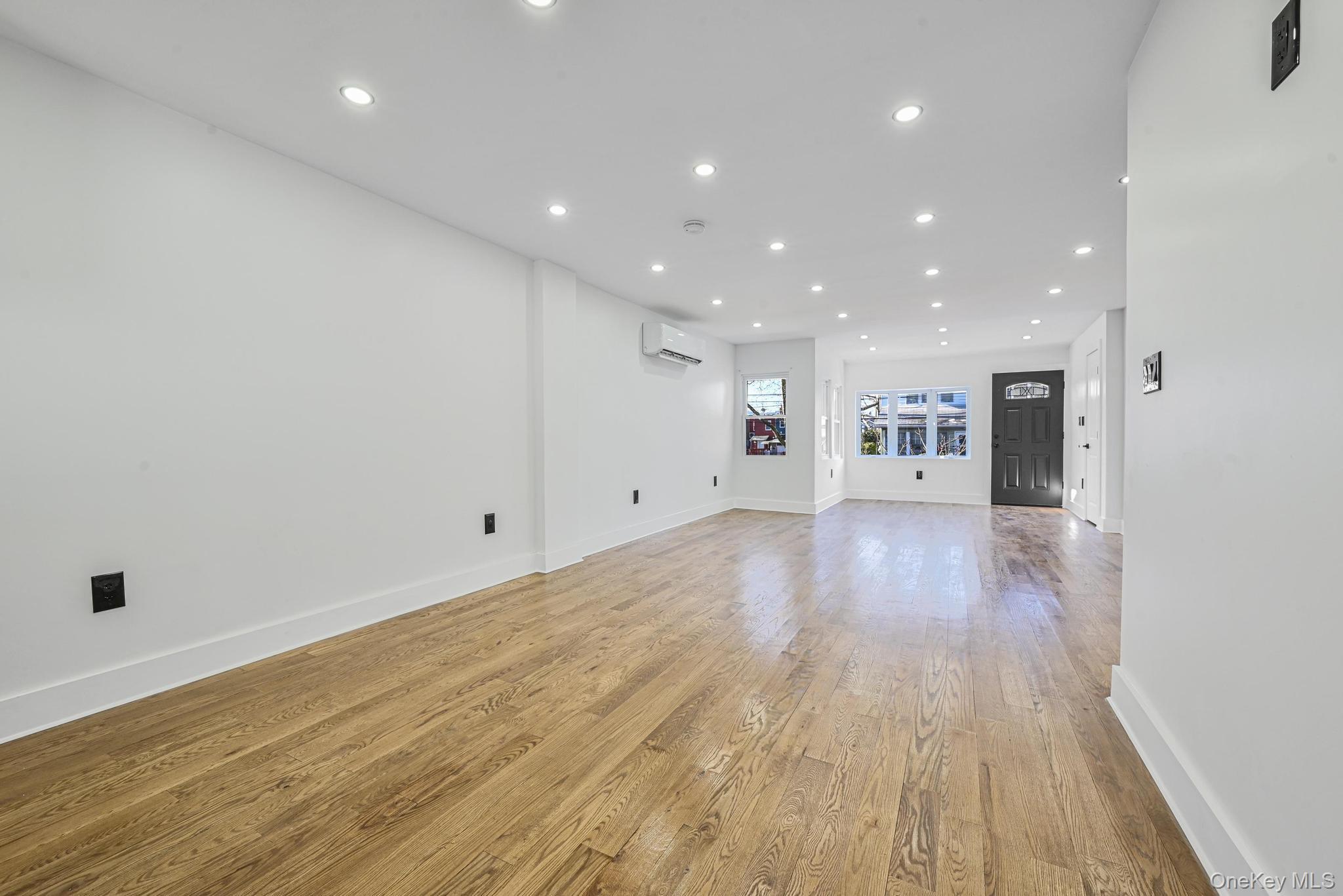 92-43 76th Street Queens, NY 11421 - Photo 13 of 20 Unfurnished living room featuring recessed lighting, light wood-style floors, and a wall mounted air conditioner
