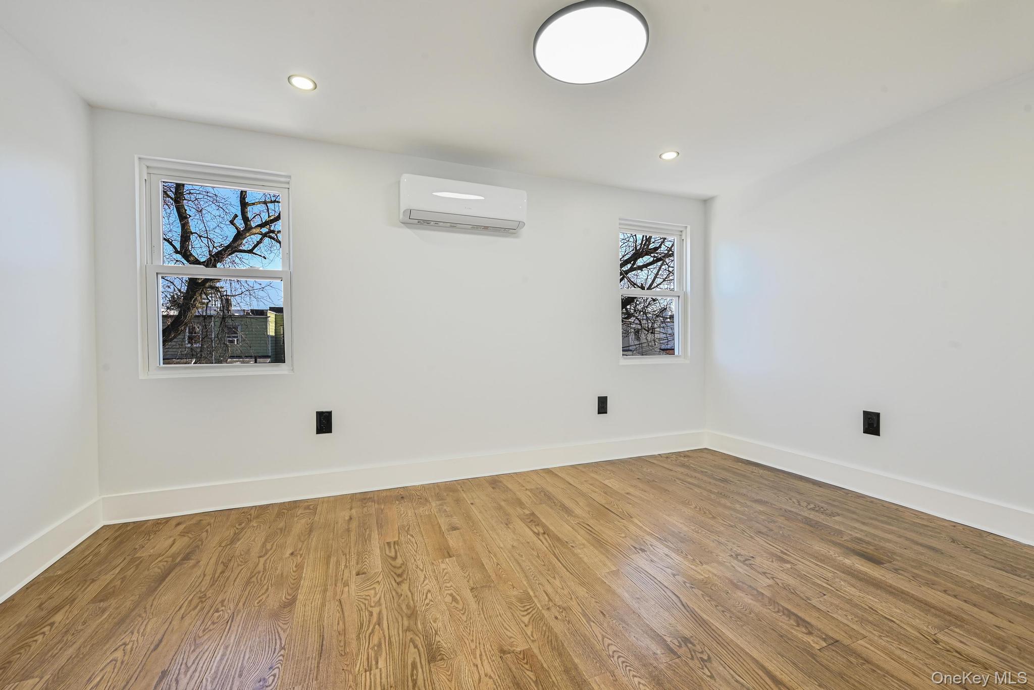 92-43 76th Street Queens, NY 11421 - Photo 16 of 20 Unfurnished room with light wood finished floors, recessed lighting, and an AC wall unit
