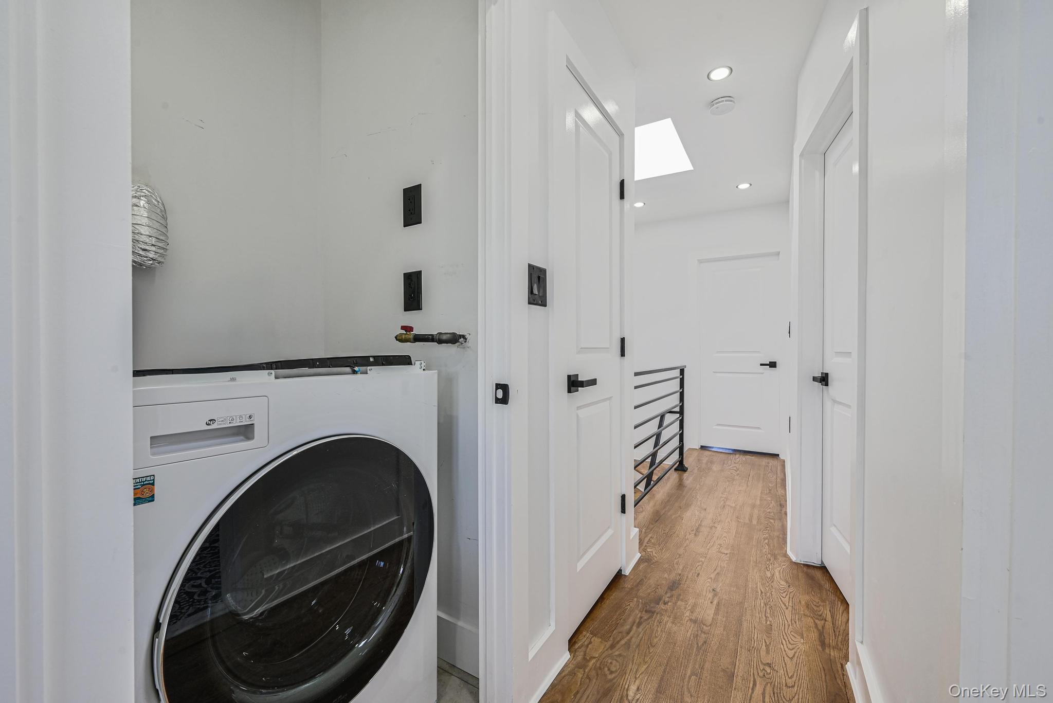 92-43 76th Street Queens, NY 11421 - Photo 18 of 20 Washroom featuring washer / clothes dryer, light wood-style floors, recessed lighting, and a skylight