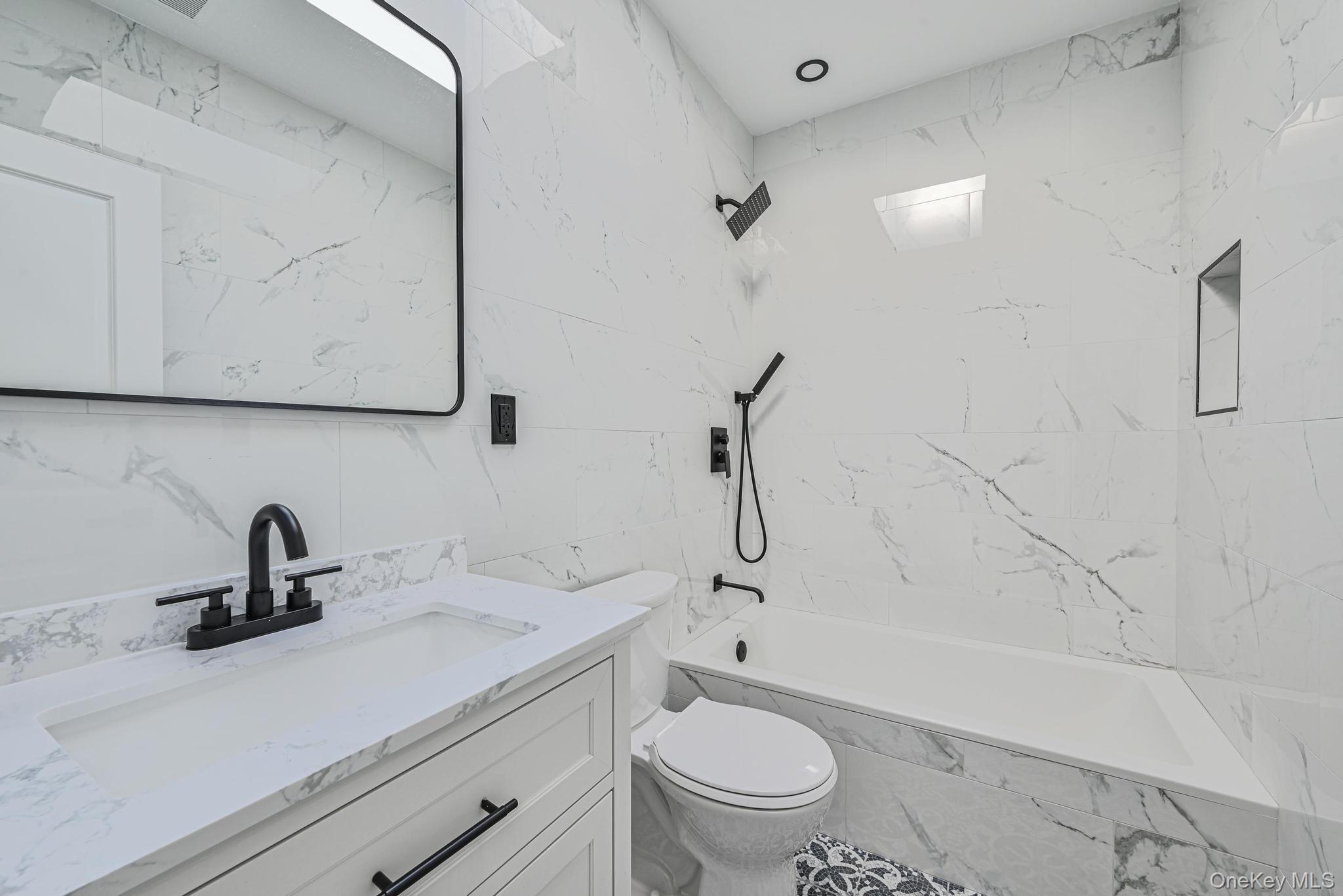 92-43 76th Street Queens, NY 11421 - Photo 5 of 20 Full bath featuring tile walls, vanity, and tiled shower / bath