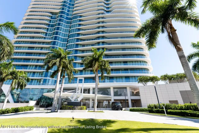 a front view of multi story residential apartment building with yard and outdoor seating