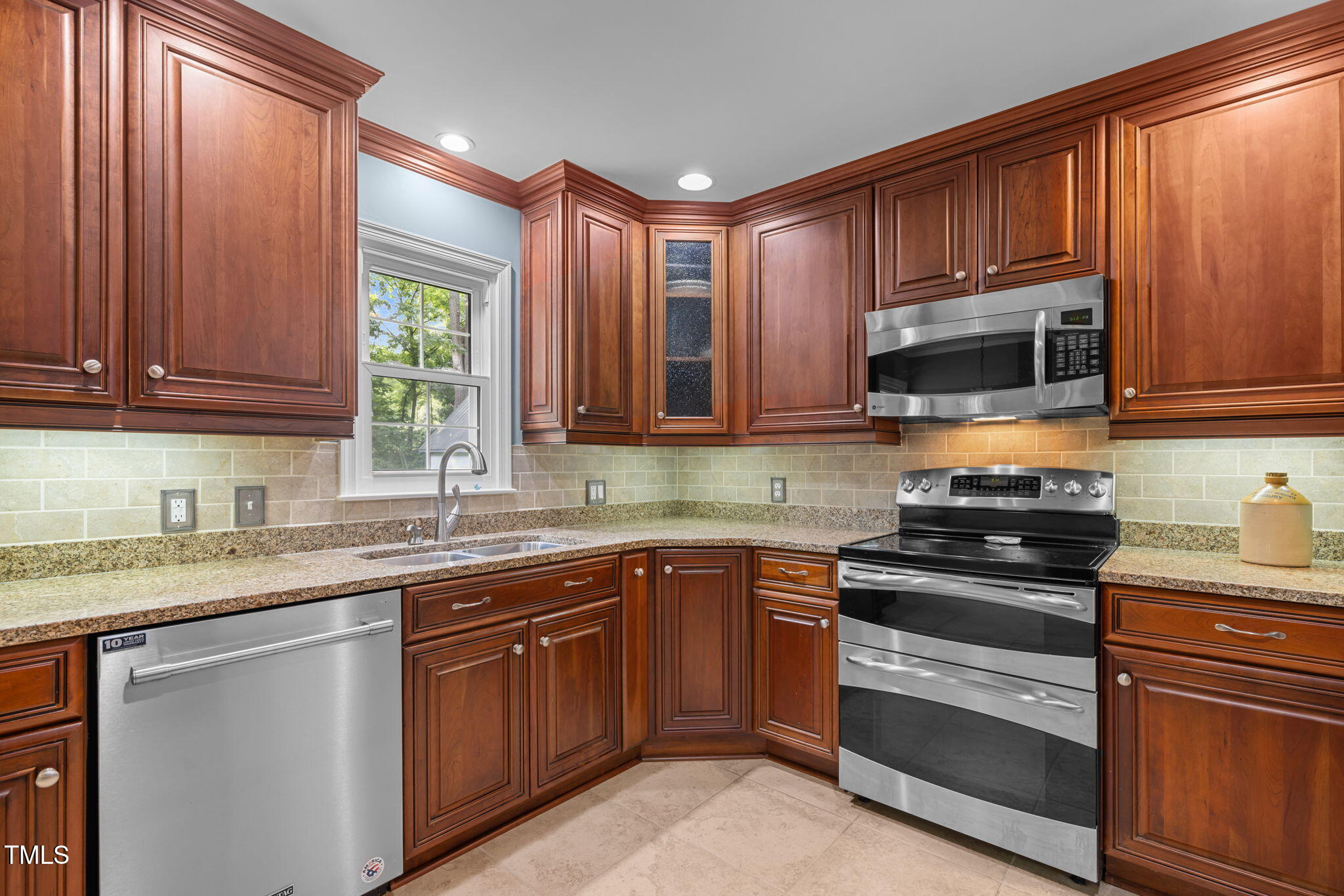 219 Barclay Road Durham, NC 27712 - Photo 10 of 36 a kitchen with stainless steel appliances granite countertop wooden cabinets a stove top oven a sink and dishwasher