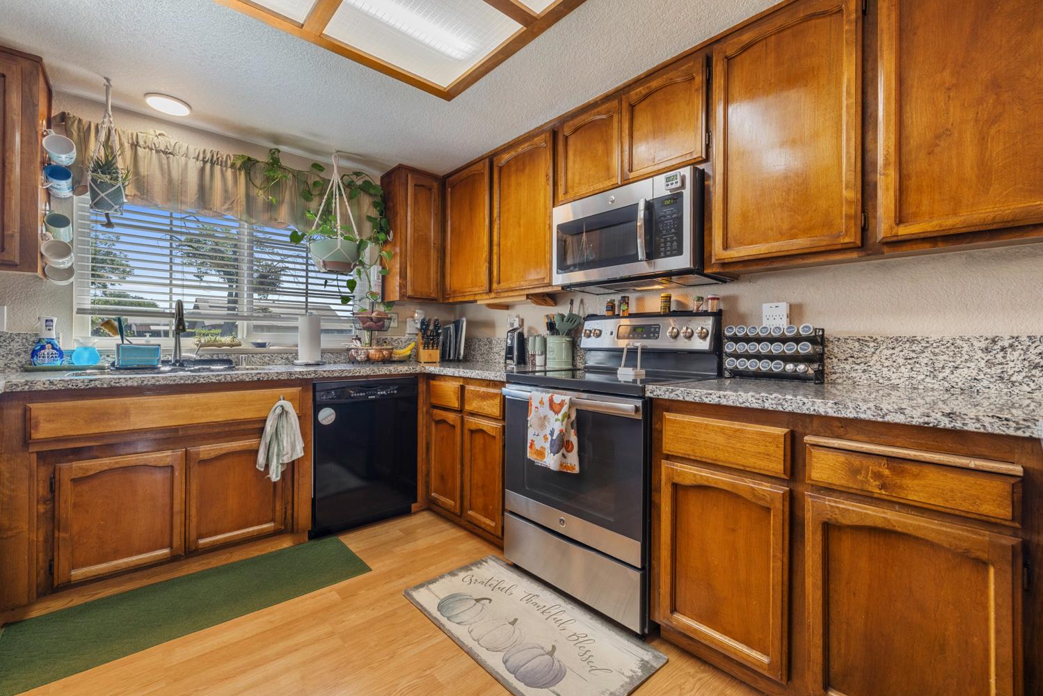 1121 Raymond Drive Modesto, CA 95351 - Photo 11 of 44 a kitchen with stainless steel appliances granite countertop wooden cabinets a sink and dishwasher