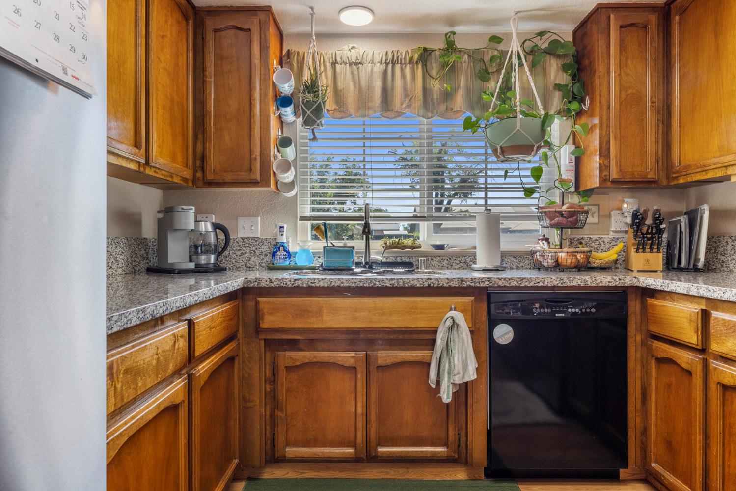 1121 Raymond Drive Modesto, CA 95351 - Photo 12 of 44 a kitchen with stainless steel appliances granite countertop a sink and cabinets