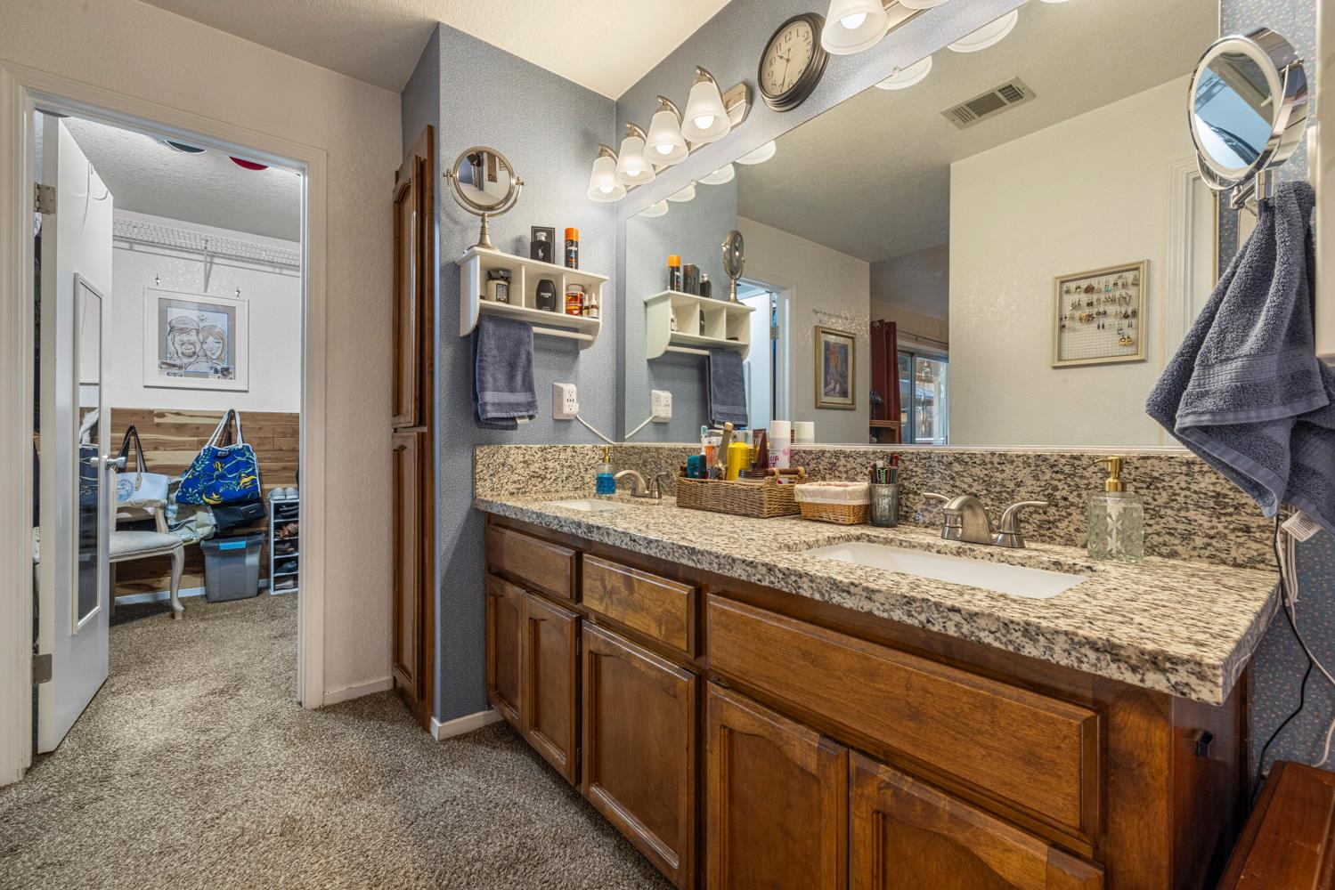 1121 Raymond Drive Modesto, CA 95351 - Photo 24 of 44 a bathroom with a granite countertop sink a large mirror and a view of living room