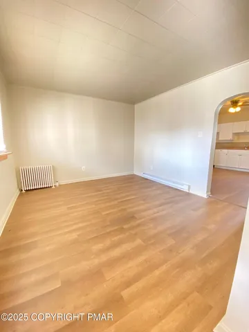 a kitchen with stainless steel appliances granite countertop a refrigerator a sink dishwasher a stove and white countertops with wooden floor