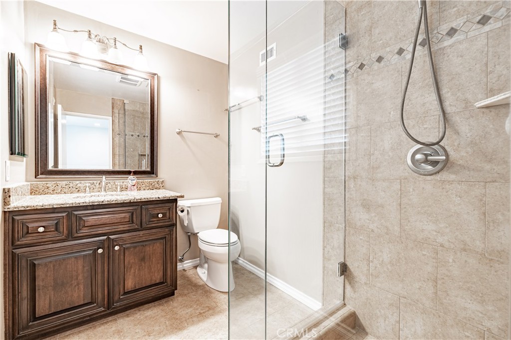 4580 Hazelnut Avenue Seal Beach, CA 90740 - Photo 23 of 34 a bathroom with a granite countertop sink a toilet and a mirror