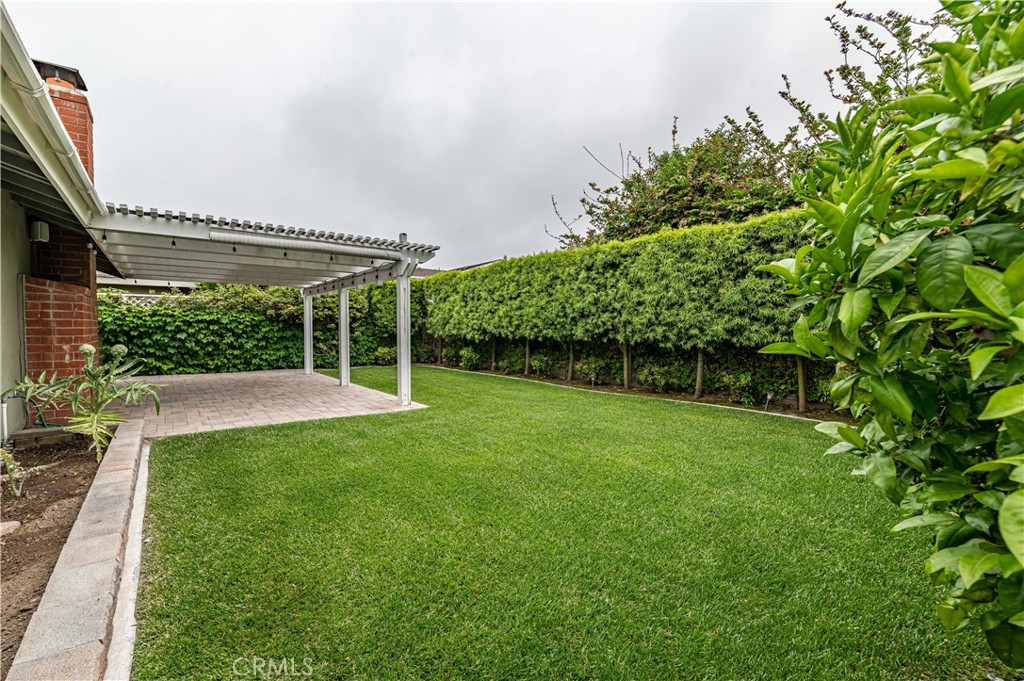 4580 Hazelnut Avenue Seal Beach, CA 90740 - Photo 30 of 34 a view of a patio with table and chairs under an umbrella
