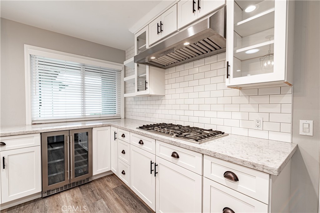 4580 Hazelnut Avenue Seal Beach, CA 90740 - Photo 7 of 34 a kitchen with granite countertop a stove and a white wooden cabinets