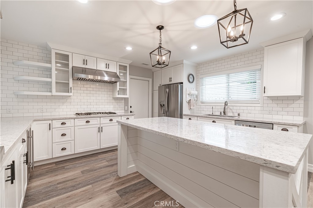 4580 Hazelnut Avenue Seal Beach, CA 90740 - Photo 9 of 34 a large kitchen with granite countertop a sink and dishwasher a stove top oven with wooden floor