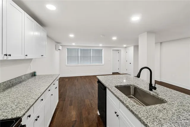 a kitchen with granite countertop a sink a stove and refrigerator