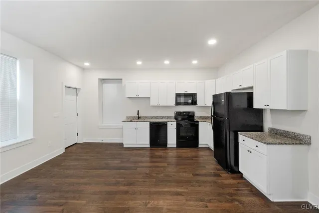 a kitchen with stainless steel appliances kitchen island granite countertop a refrigerator and a stove