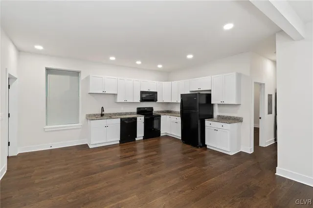a kitchen with a refrigerator and a stove top oven