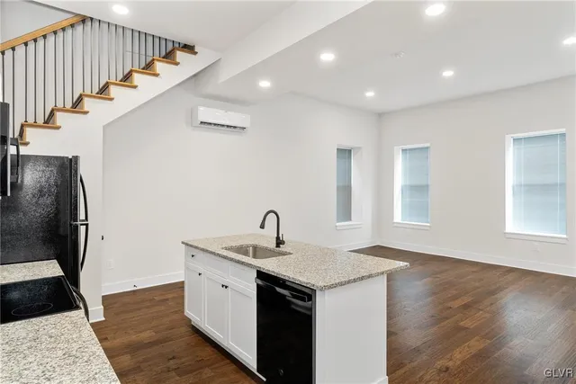 a kitchen with stainless steel appliances granite countertop a sink a stove and a refrigerator