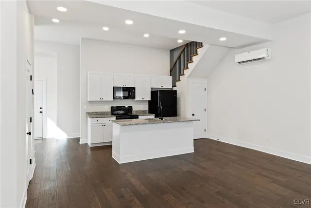 a kitchen with stainless steel appliances kitchen island a refrigerator a sink a stove and microwave