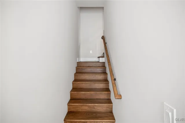 an empty room with wooden floor and window