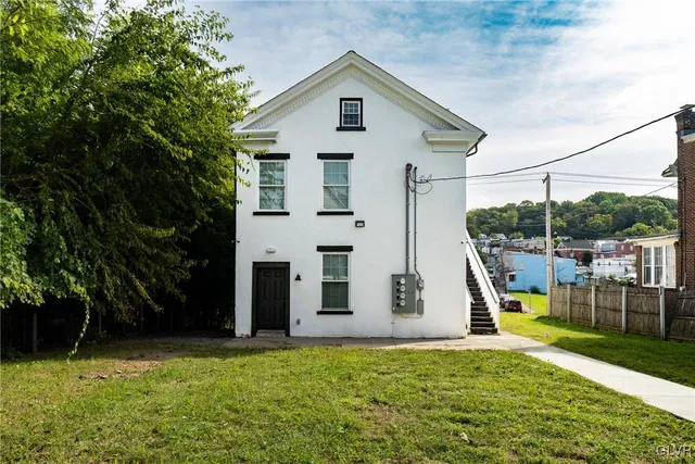 a view of a house with backyard and a tree