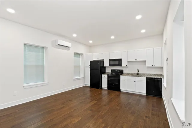 a kitchen with stainless steel appliances a refrigerator and wooden floor