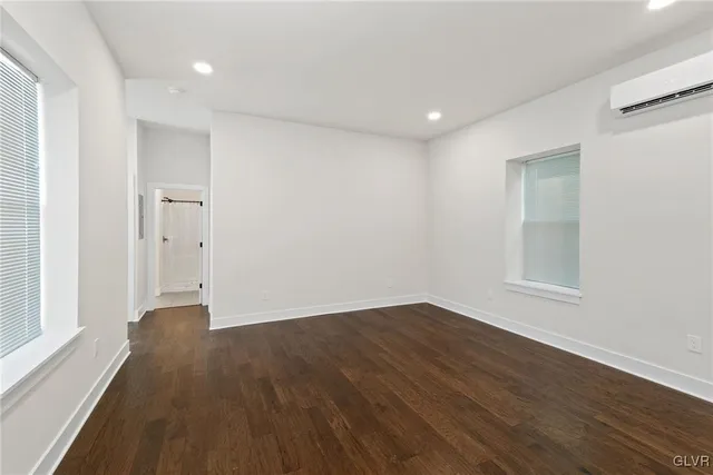 a view of a livingroom with a washing machine and wooden floor