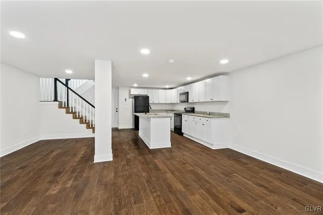 a kitchen with wooden floors and white cabinets