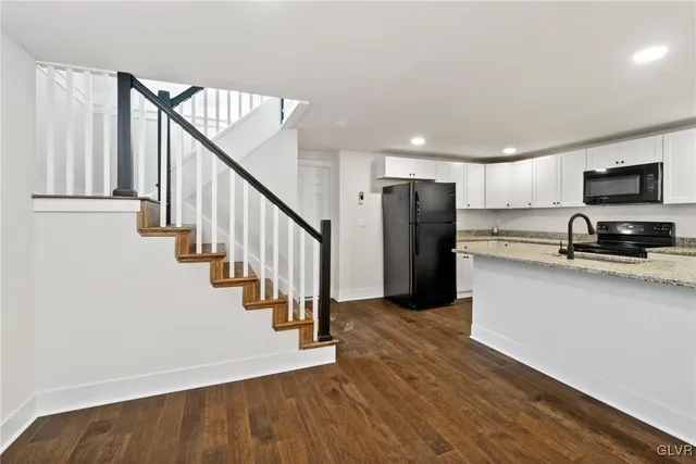 a view of a kitchen with wooden floor and electronic appliances