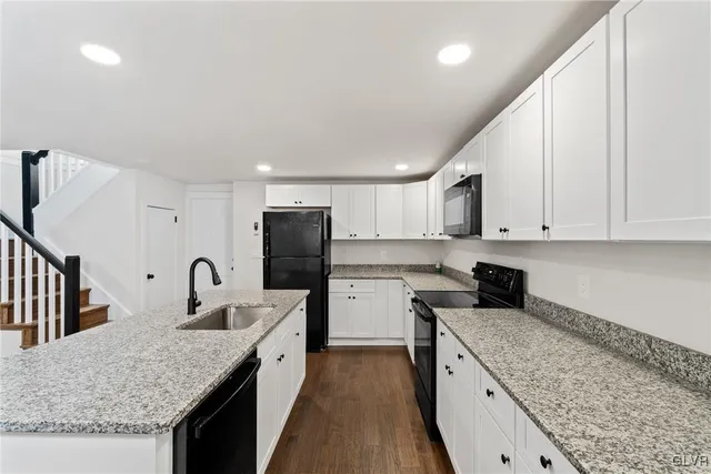 a kitchen with lot of counter top space cabinets and stainless steel appliances