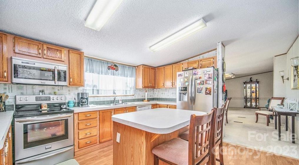 713 Bailey Sawmill Road Ruby, SC 29741 - Photo 13 of 30 a kitchen with stainless steel appliances granite countertop a stove a refrigerator a dining table and chairs