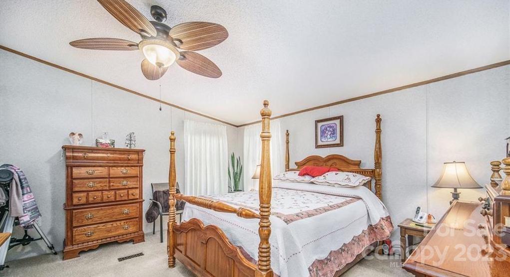 713 Bailey Sawmill Road Ruby, SC 29741 - Photo 22 of 30 a bedroom with a bed and a chandelier