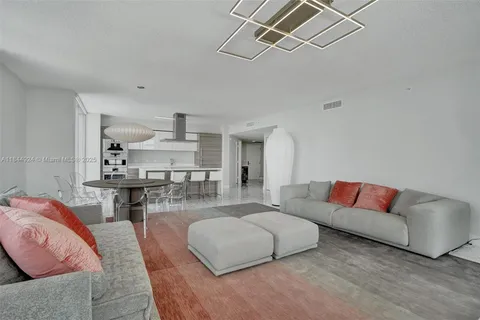 a living room with furniture and kitchen view