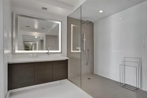 a bathroom with a shower sink and mirror