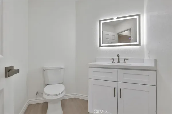 a bathroom with a toilet sink vanity and mirror