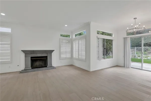 a view of an empty room with windows and a fireplace