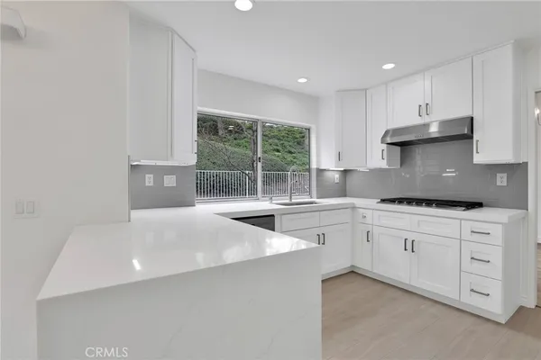 a kitchen with stainless steel appliances a sink stove and cabinets