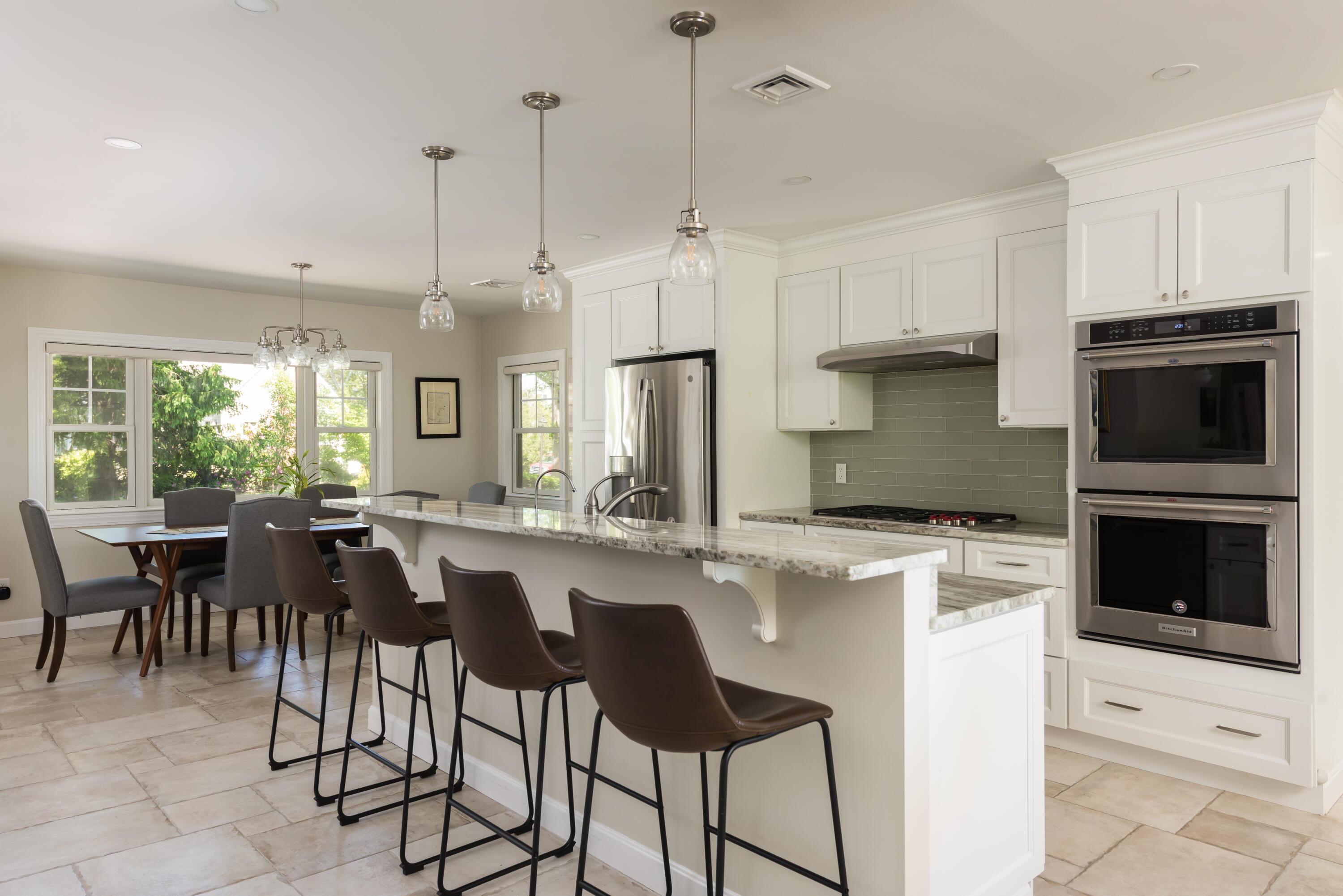 180 Riverview Lane Centerville, MA 02632 - Photo 15 of 55 a kitchen with a table chairs microwave and cabinets