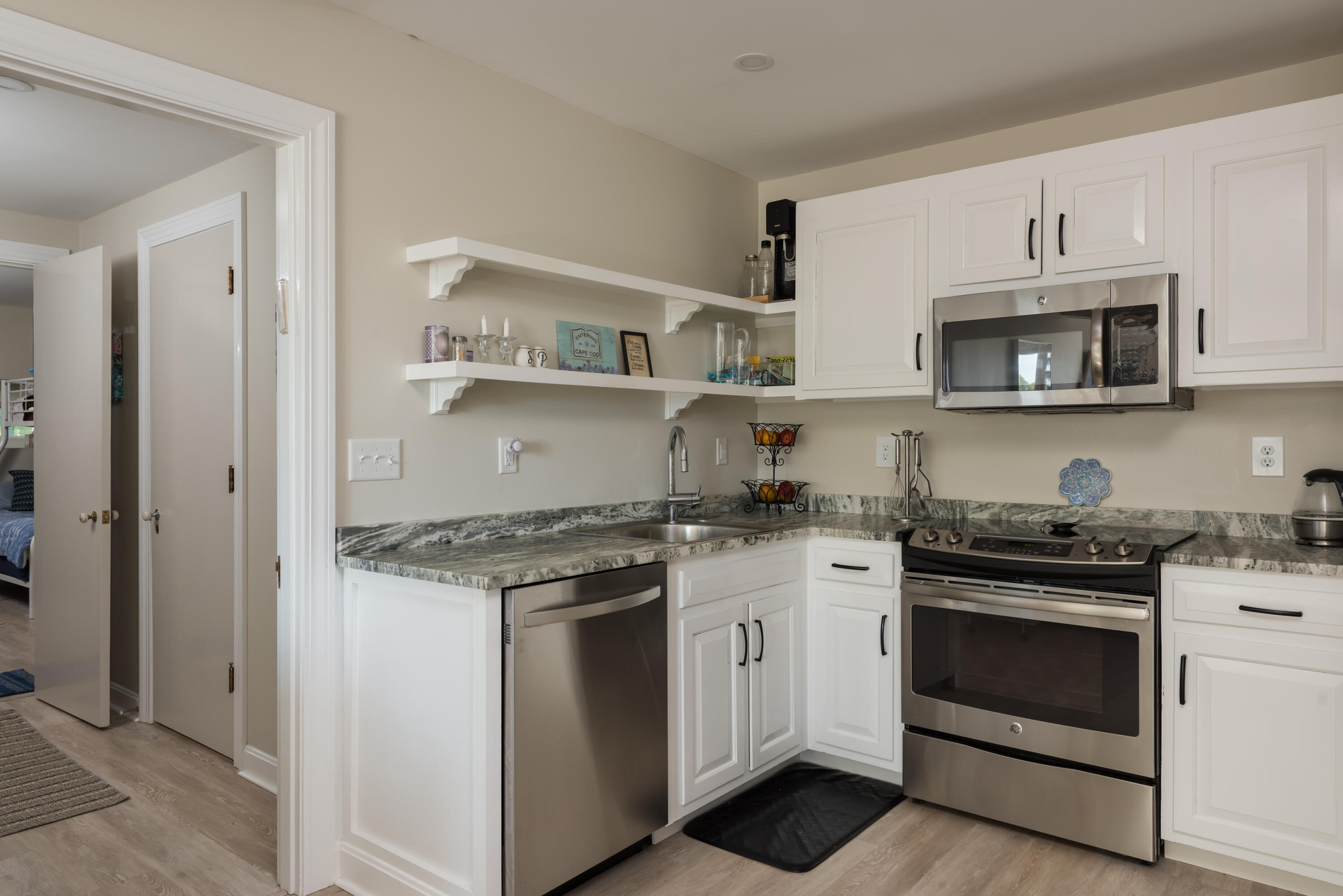 180 Riverview Lane Centerville, MA 02632 - Photo 32 of 55 a kitchen with granite countertop white cabinets and stainless steel appliances