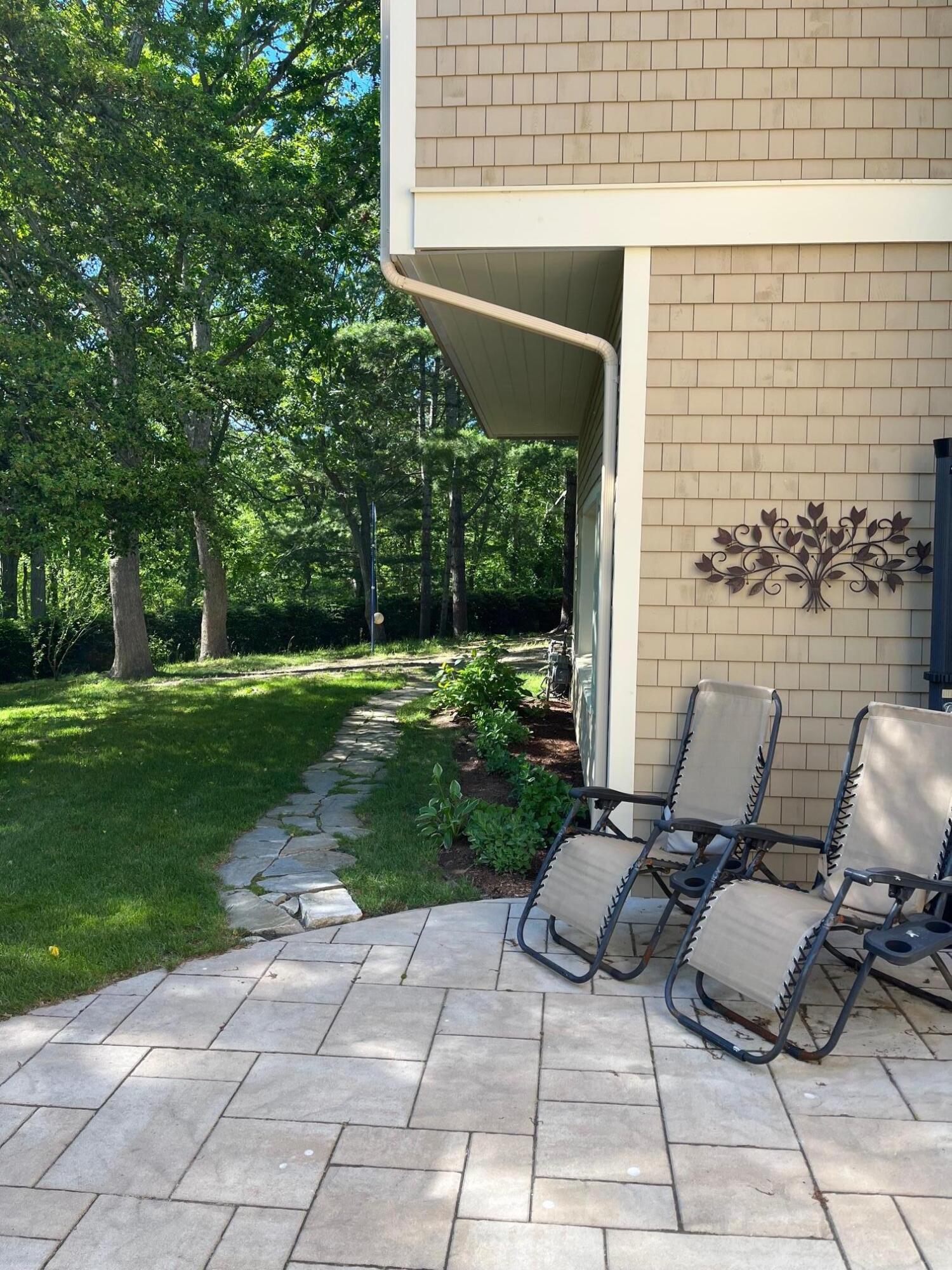 180 Riverview Lane Centerville, MA 02632 - Photo 41 of 55 a backyard of a house with outdoor seating