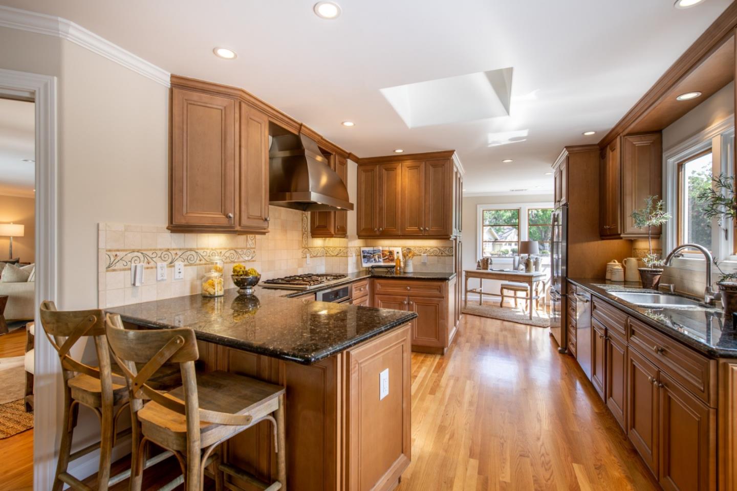 630 Covington Road Los Altos, CA 94024 - Photo 9 of 27 a kitchen with stainless steel appliances granite countertop a stove top oven a sink dishwasher a dining table and chairs with wooden floor