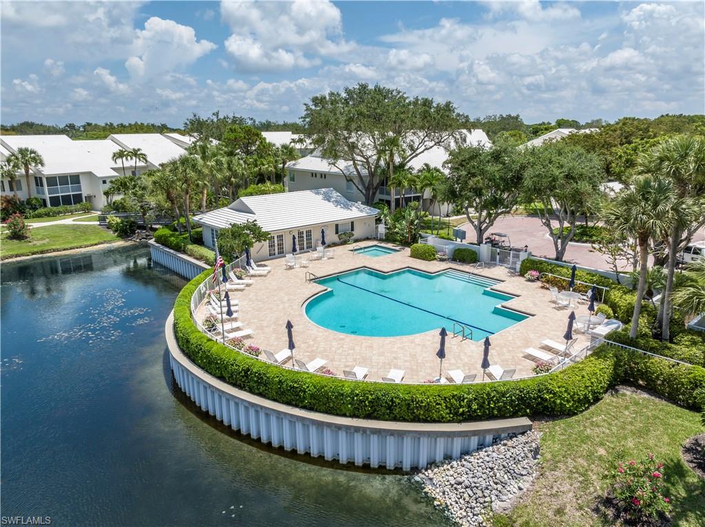 760 Willowbrook Drive, Unit 1202 Naples, FL 34108 - Photo 1 of 28 a view of a swimming pool with a garden