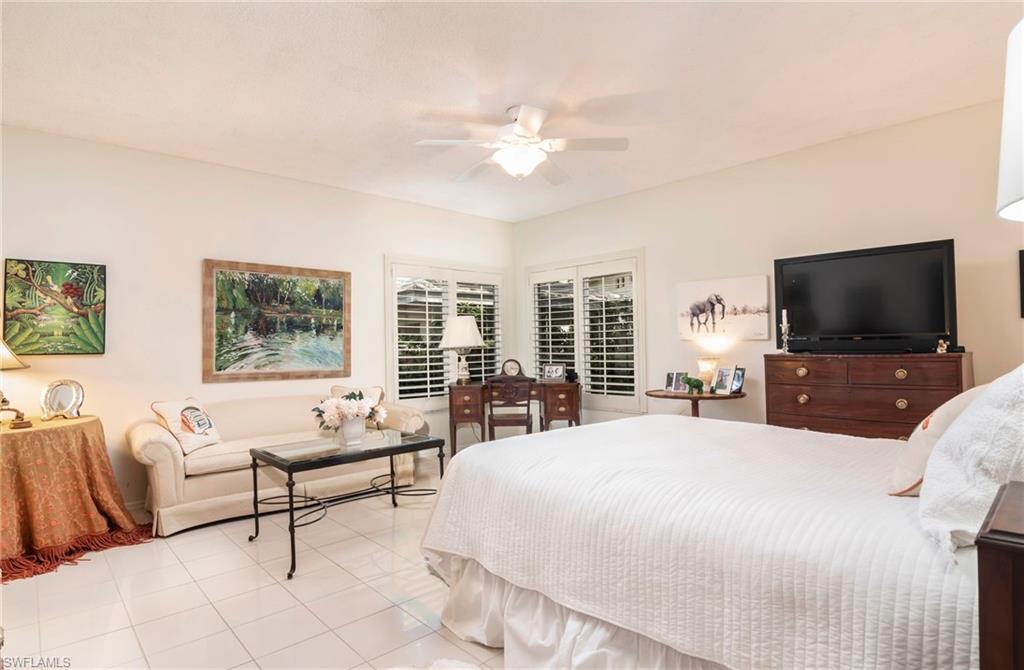 760 Willowbrook Drive, Unit 1202 Naples, FL 34108 - Photo 11 of 28 a bedroom with a bed and a flat screen tv