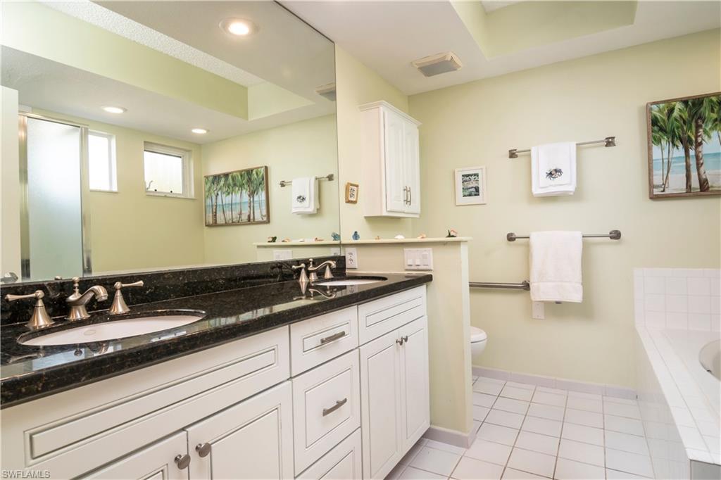 760 Willowbrook Drive, Unit 1202 Naples, FL 34108 - Photo 13 of 28 a bathroom with a granite countertop sink a mirror a and a