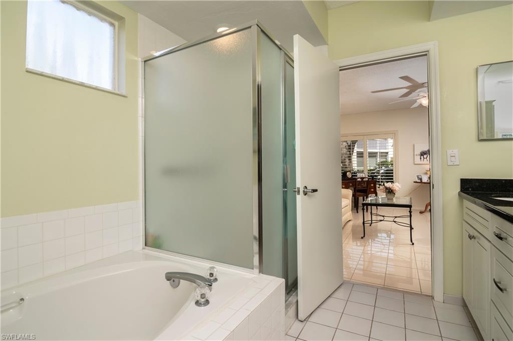 760 Willowbrook Drive, Unit 1202 Naples, FL 34108 - Photo 14 of 28 a bathroom with a tub a sink and a mirror