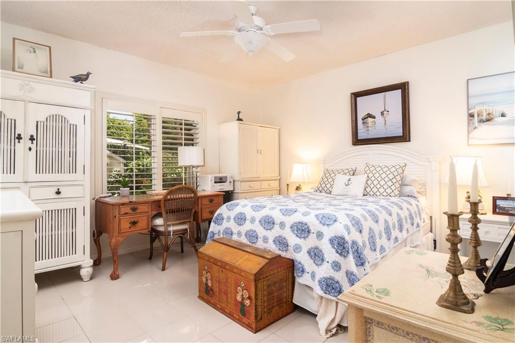 760 Willowbrook Drive, Unit 1202 Naples, FL 34108 - Photo 16 of 28 a bedroom with a bed and wooden floor