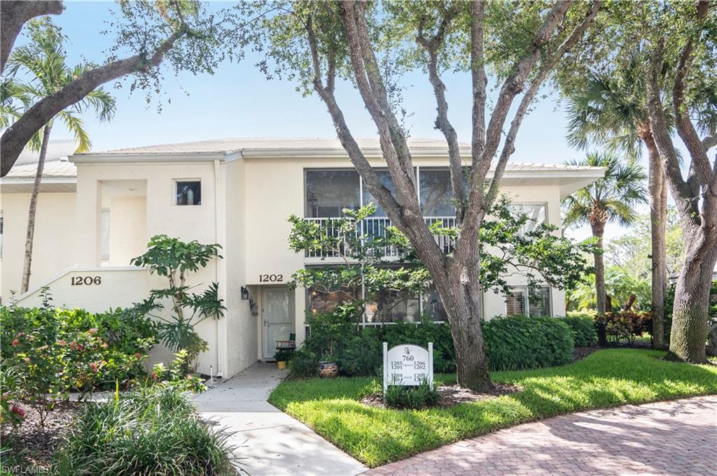 760 Willowbrook Drive, Unit 1202 Naples, FL 34108 - Photo 2 of 28 a front view of a house with garden